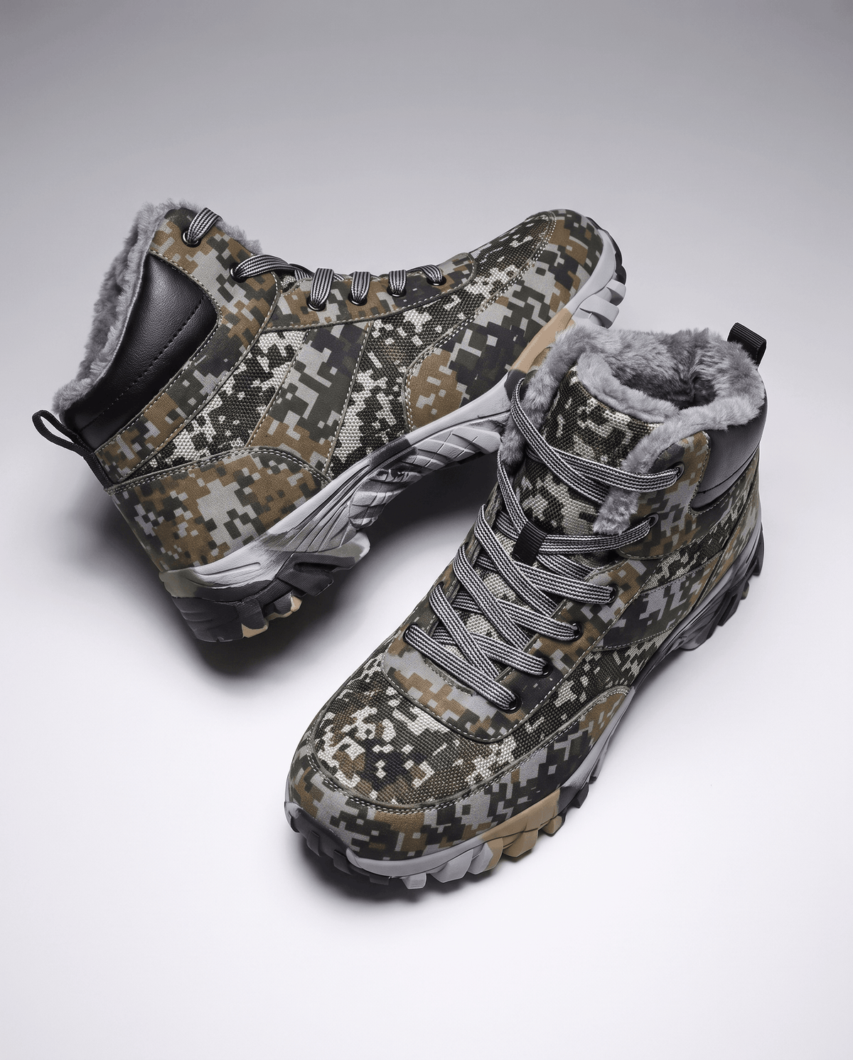 Green camo boots angled apart on white, lug tread visible along the edge
