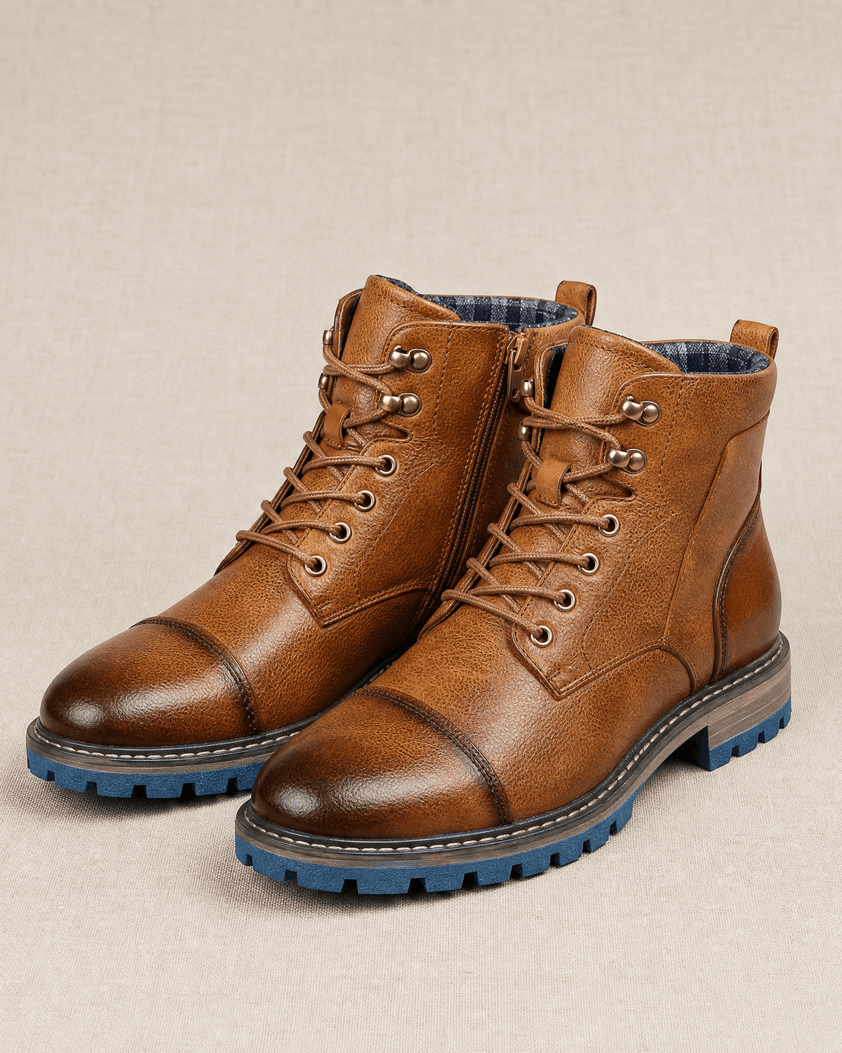 Brown smooth grain leather cap toe boots with lace-up front, side zip, and blue lug rubber outsoles on a neutral background.
