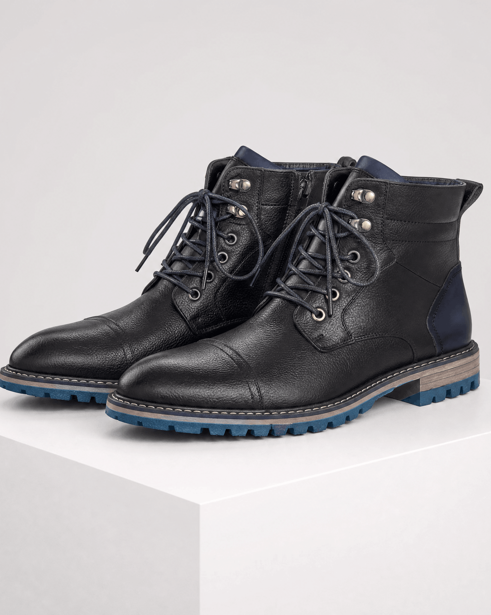 Black smooth grain leather cap toe boots with lace-up front, side zip, and a blue-accented lug rubber outsole.