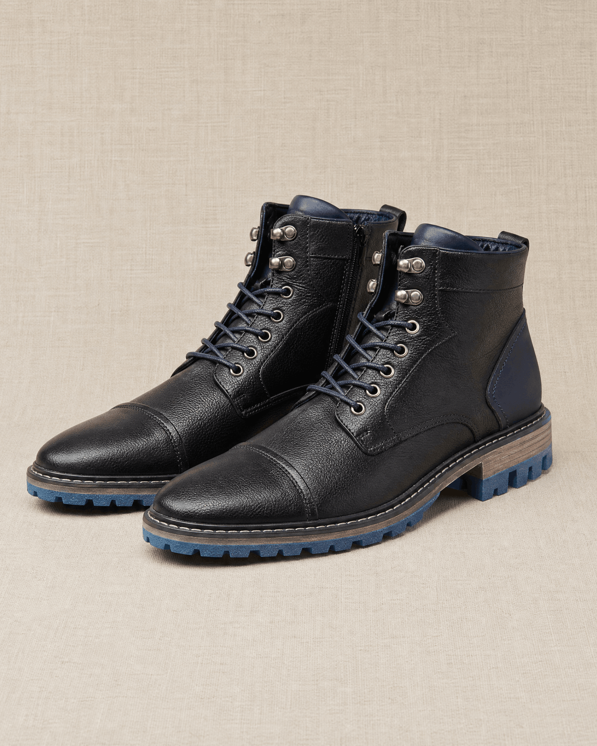 Black smooth grain leather cap toe boots with lace-up front, side zip entry, and a durable blue lug rubber outsole.