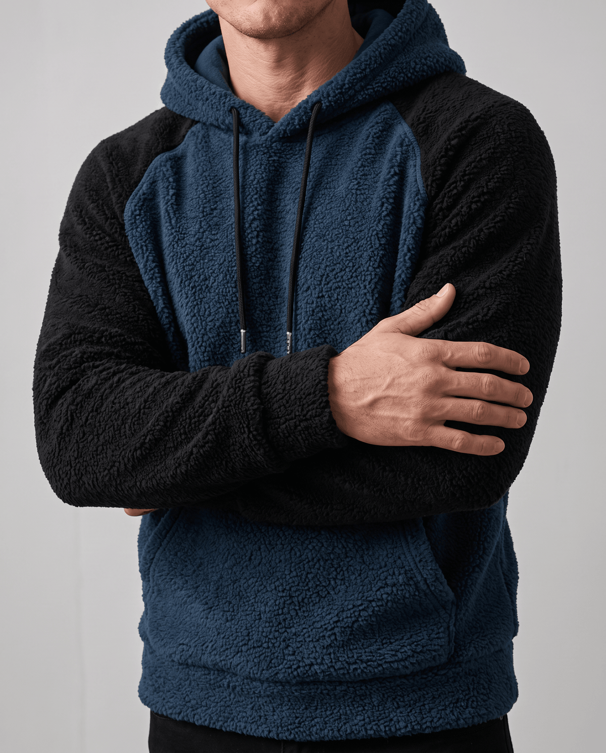 Navy blue hoodie with one arm across the body, showing drawstrings and pocket