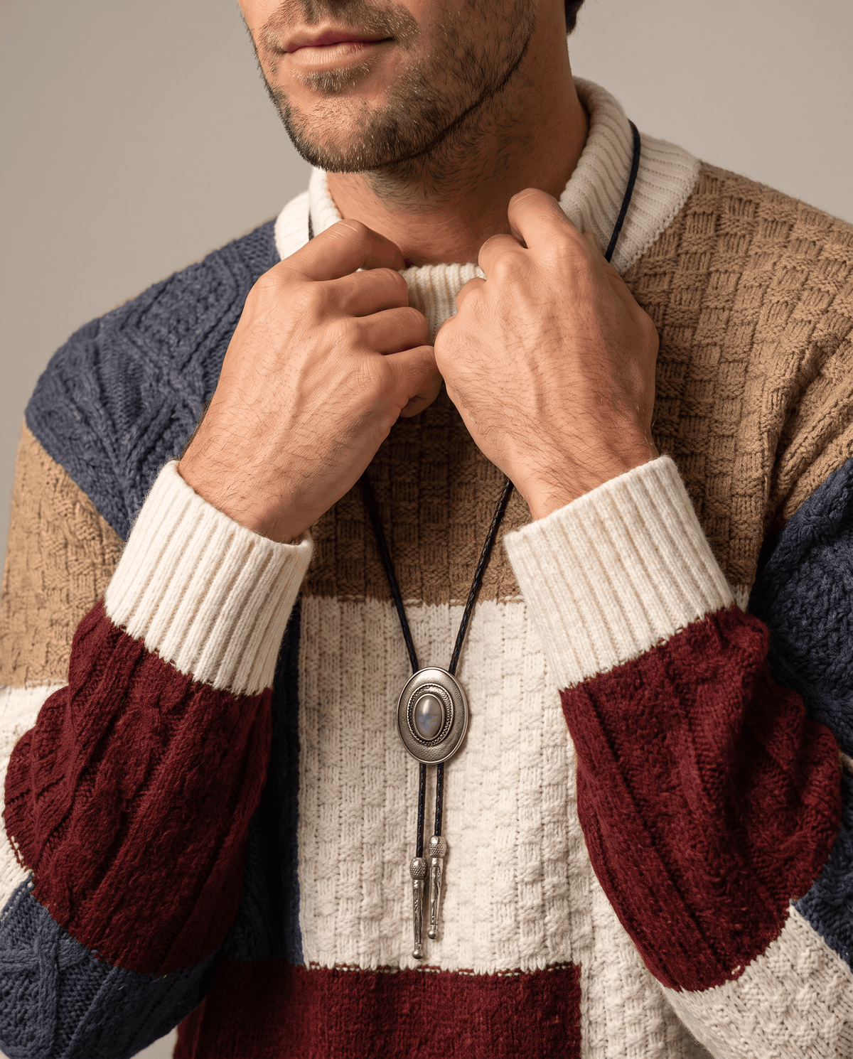 Close-up of hand at the cream ribbed mock collar with burgundy sleeve panel