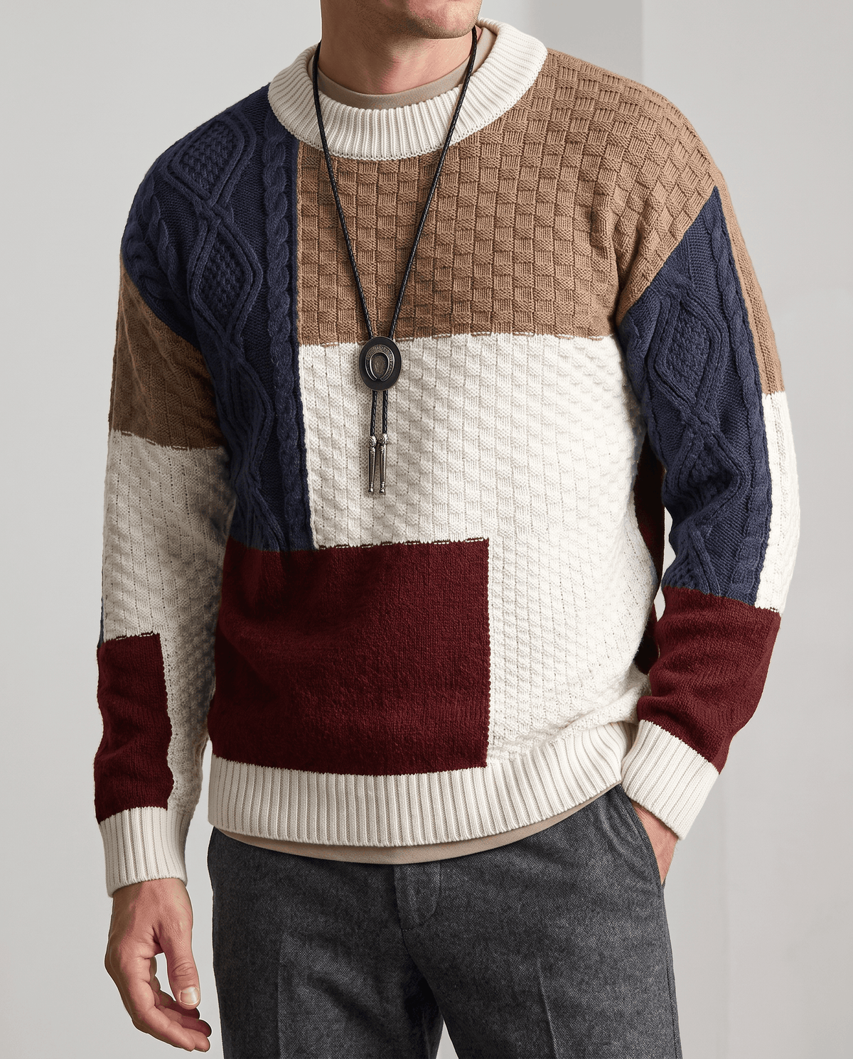 Front detail of navy, cream and burgundy colorblock knit with gray trousers