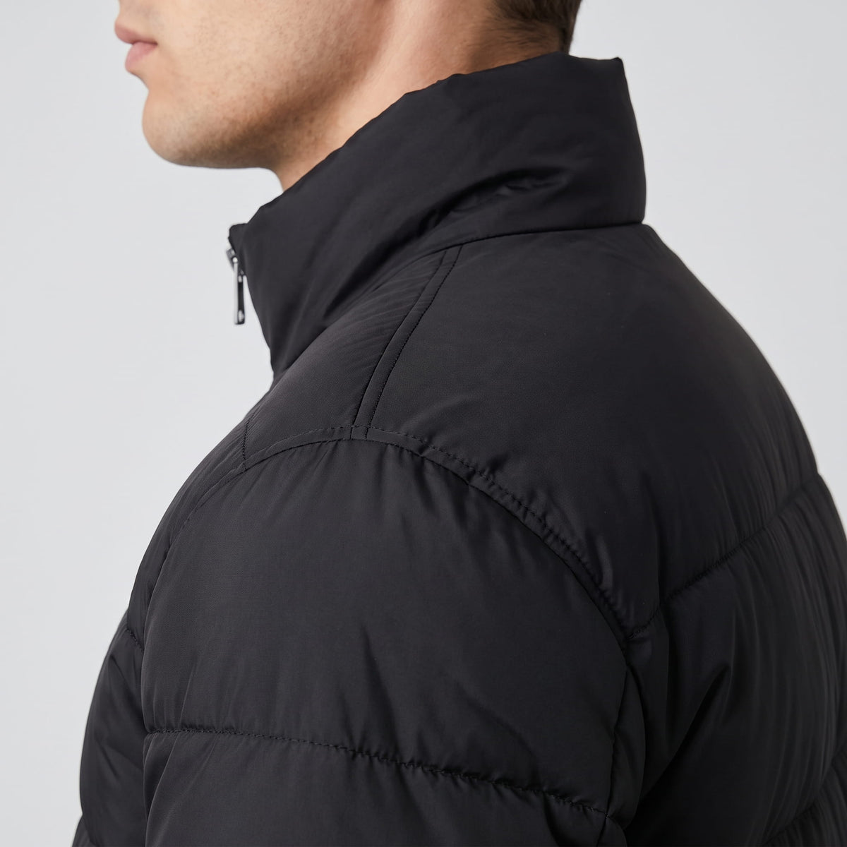 Close black collar detail showing the zip pull at the top of the stand collar