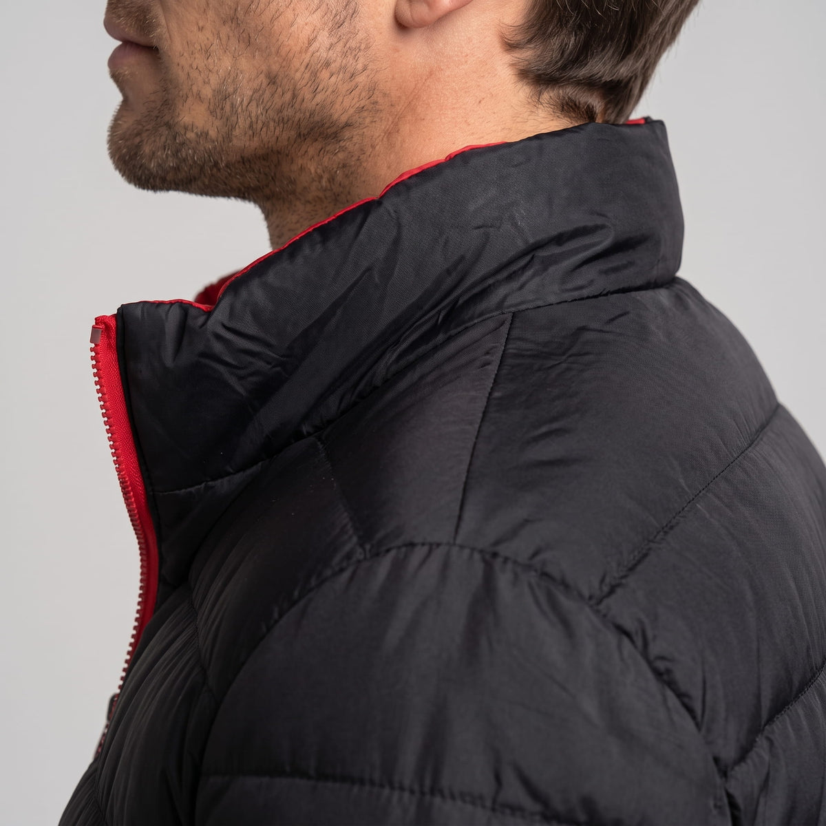 Collar detail showing red zip tape running up against the black shell
