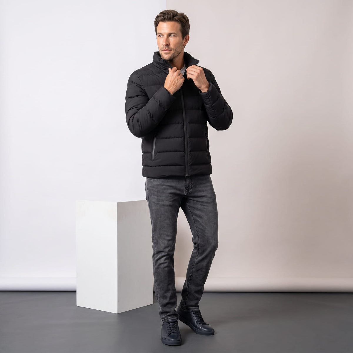 All-black jacket styled full-length with dark trousers and black boots