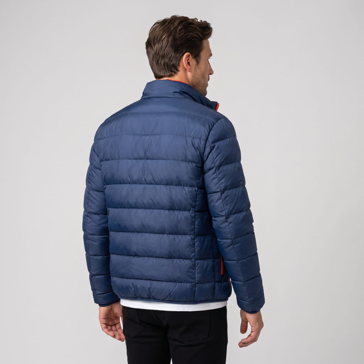 Back view in navy showing the quilted channels and hip-length hem