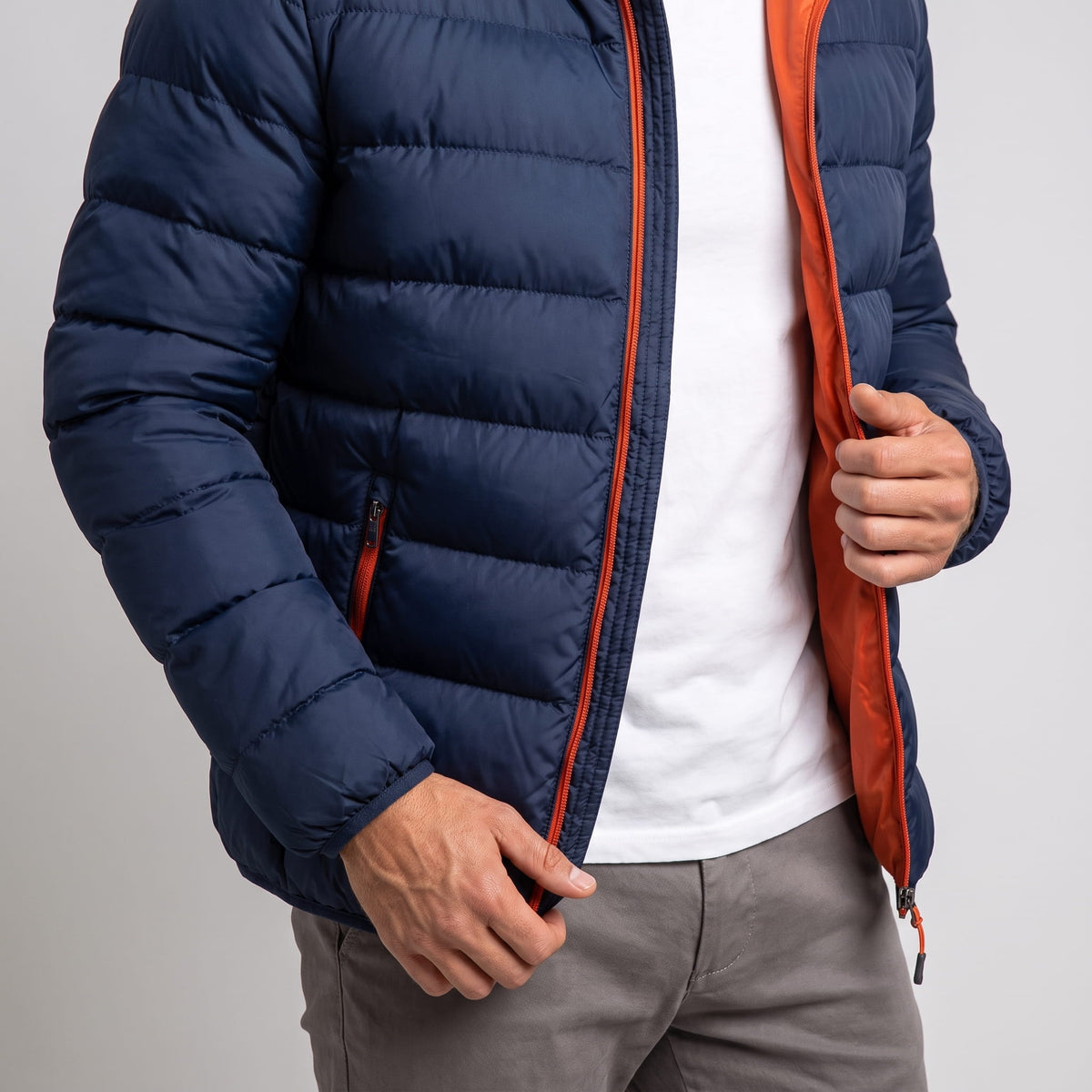 Navy jacket held open to show the orange inner lining and zip facing