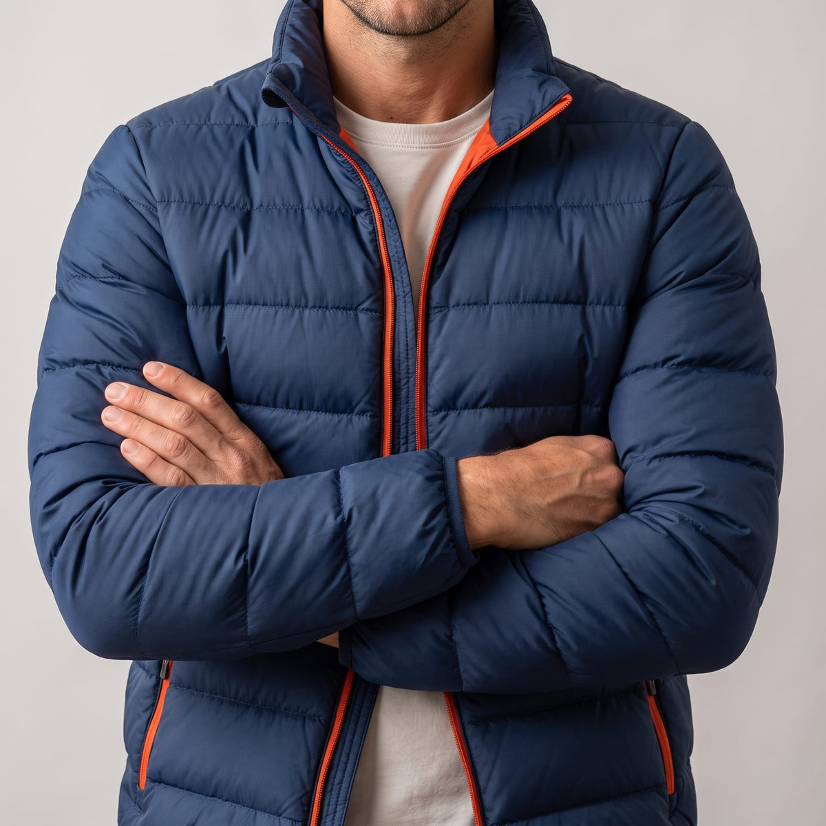 Navy torso with arms crossed, orange zip tape visible down the front