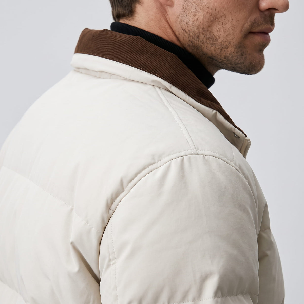 Close detail of the brown corduroy collar against the cream quilted shoulder