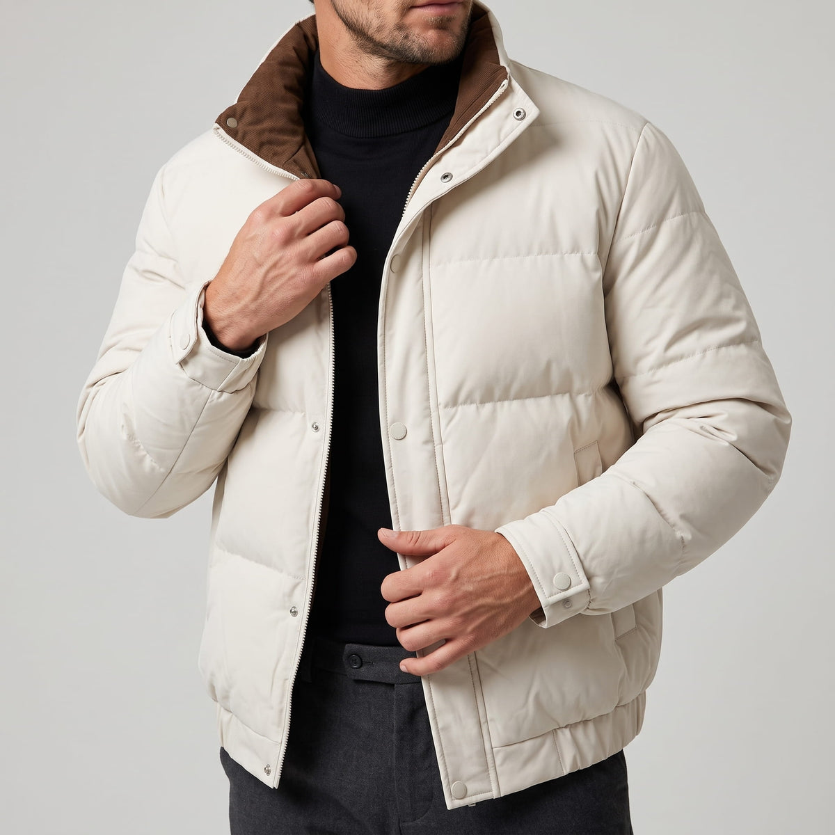 Cream jacket torso with a hand at the collar, snap placket visible