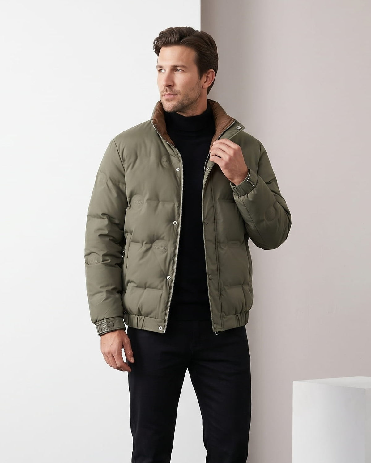 Man wearing olive puffer jacket with tan corduroy collar, worn open
