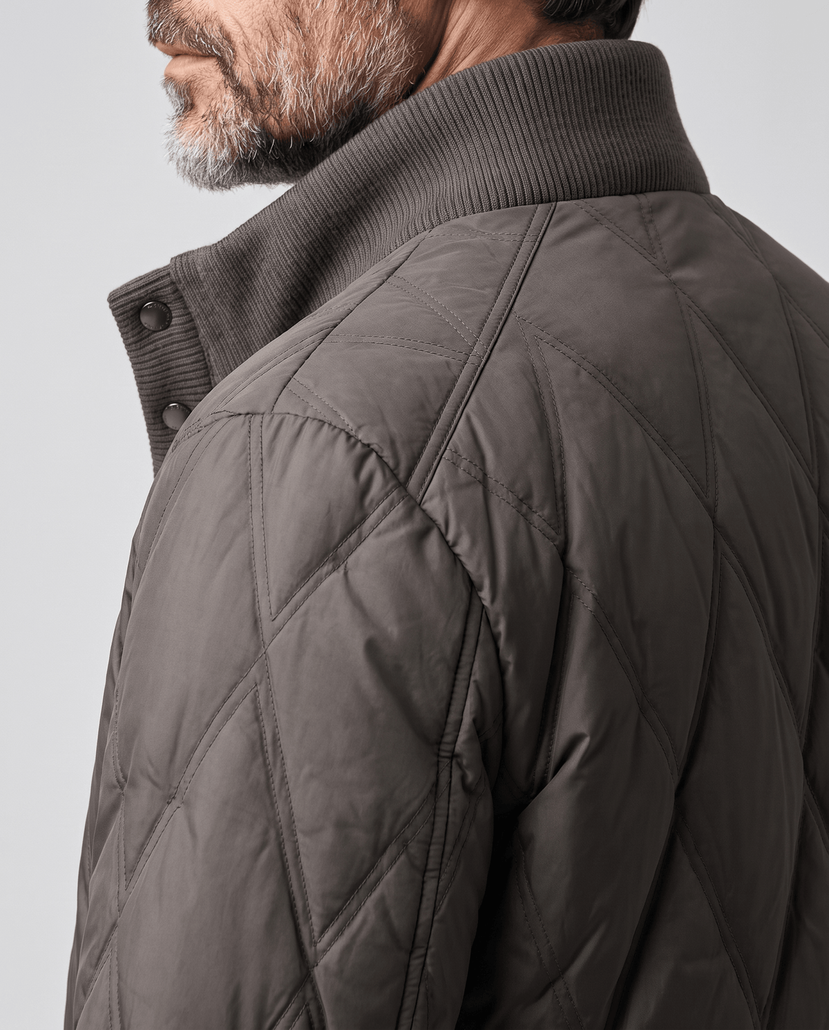 Close-up of diamond quilting and ribbed collar on a dark brown puffer jacket