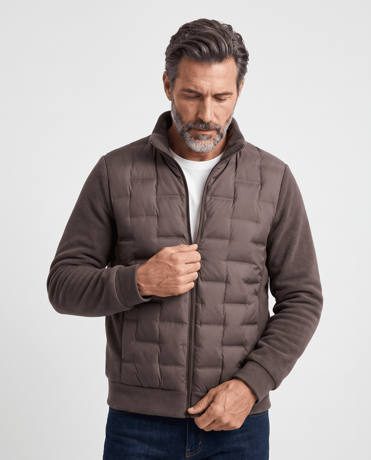 Man wearing a dark brown hybrid puffer jacket with quilted body and fleece sleeves, front view