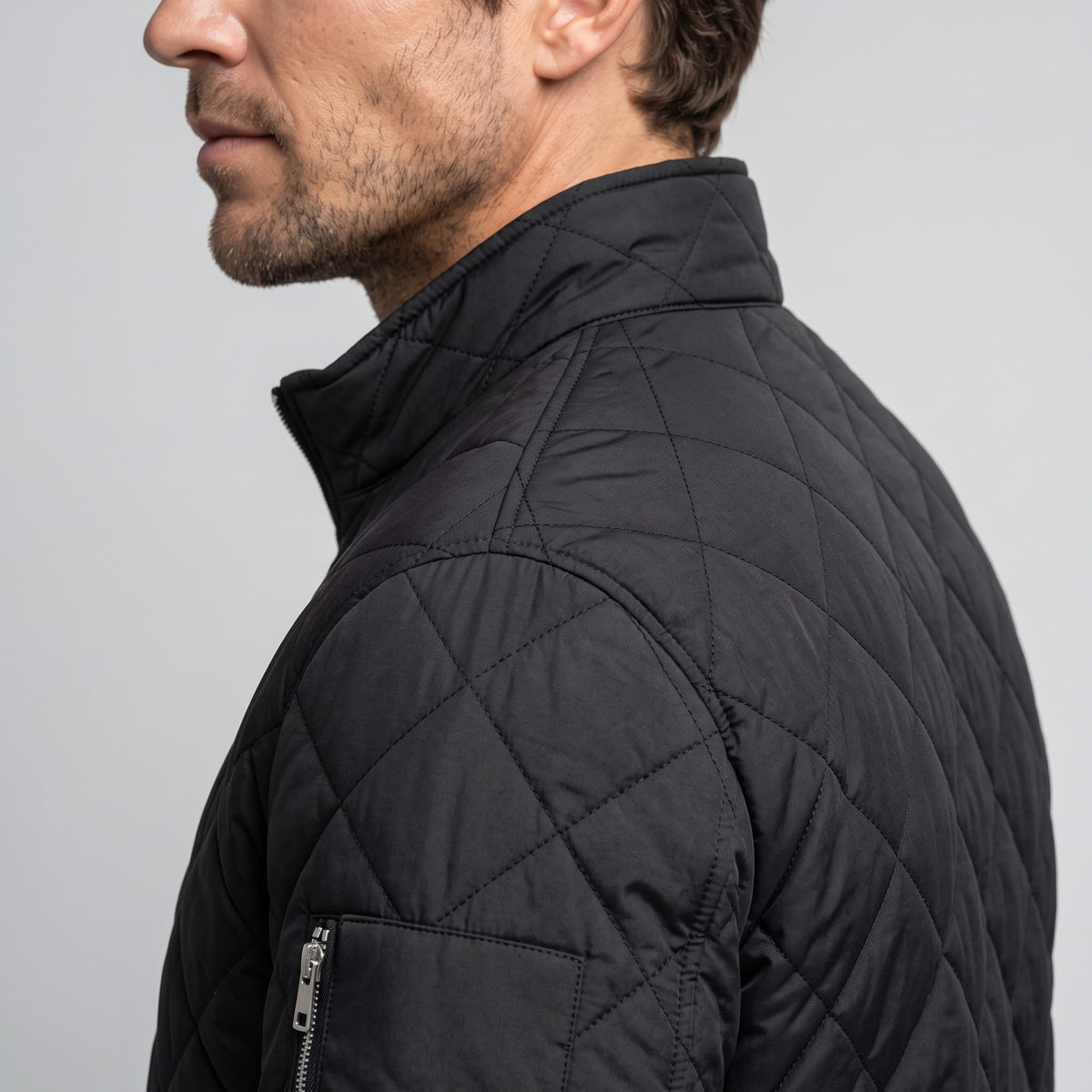 Close view of the black stand collar, shoulder quilting and zip side pocket