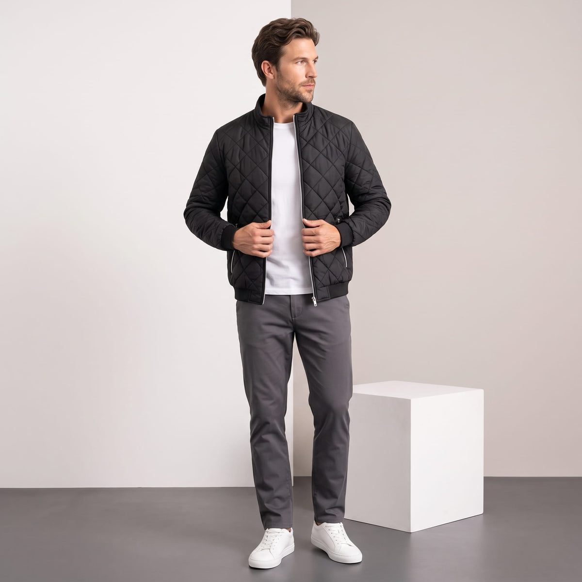 Black jacket styled full-length with grey trousers and white sneakers