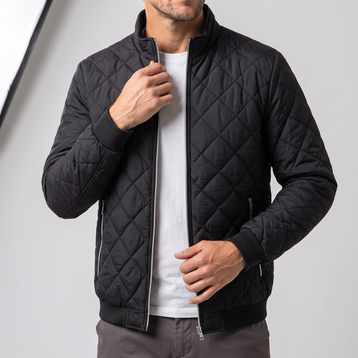 Black jacket zipped, showing the contrast zip tape and ribbed hem