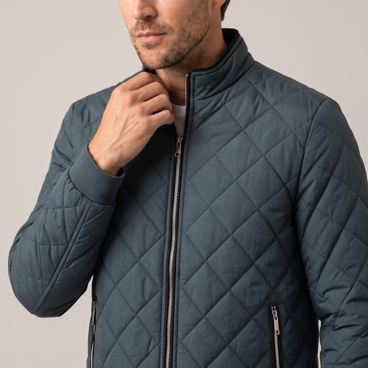 Slate blue jacket with a hand at the stand collar, full-length zip visible