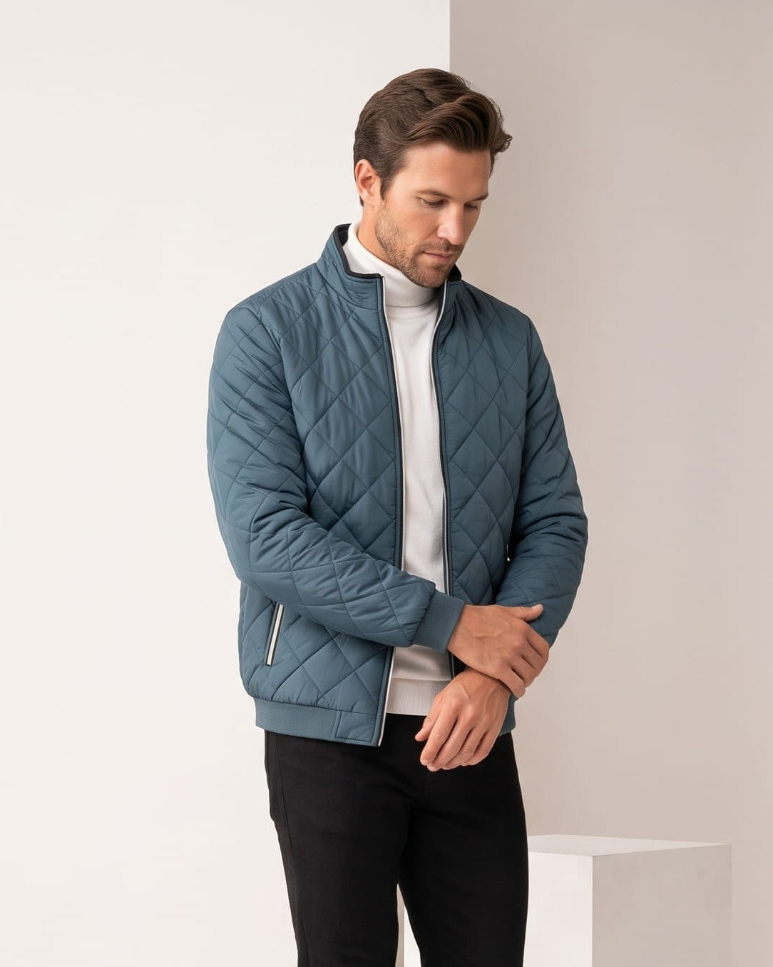 Slate blue colorway worn open over a white top, diamond quilting across the chest