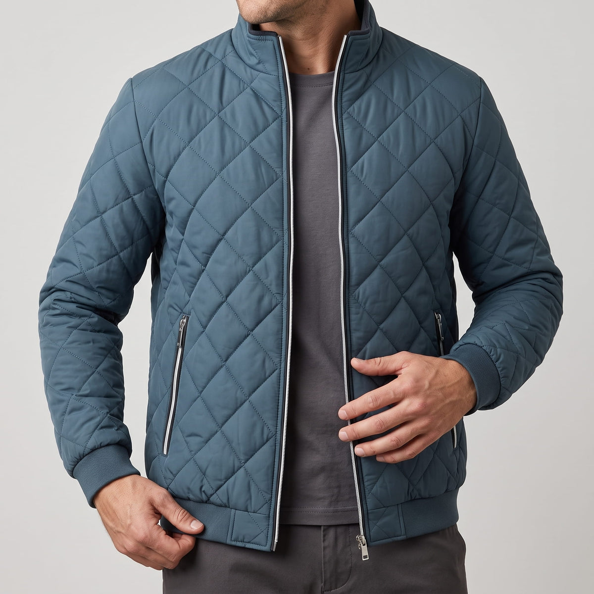 Slate blue jacket held open, showing zip side pockets and ribbed cuffs