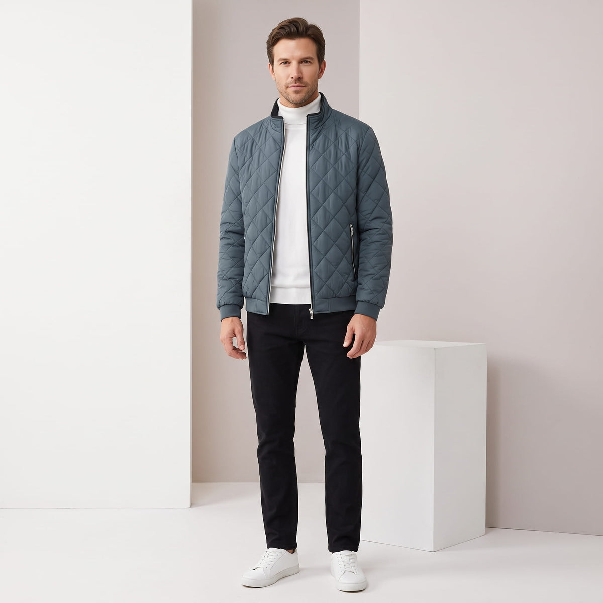 Slate blue jacket styled full-length with black jeans and white sneakers