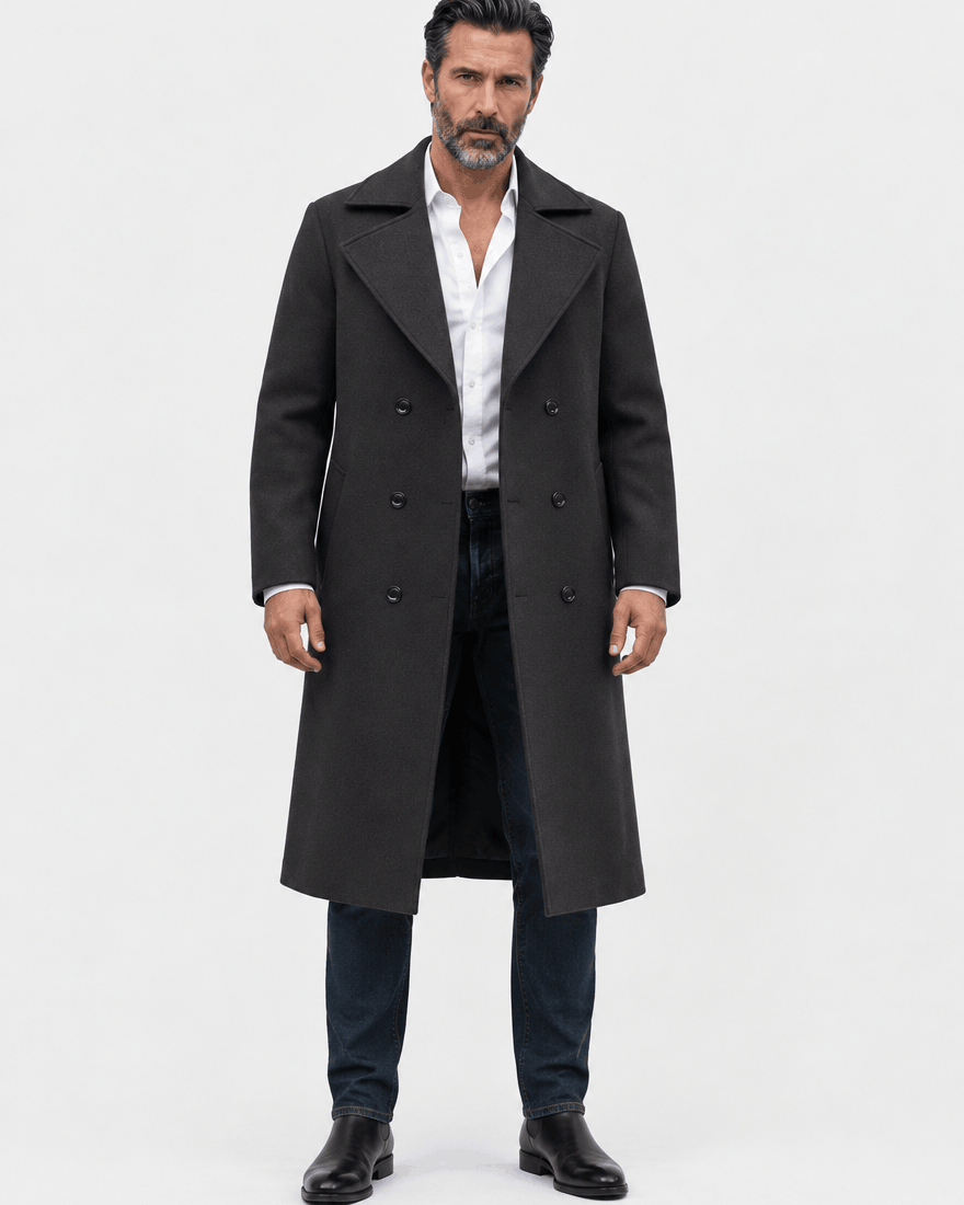 Black double-breasted overcoat worn open over dark jeans and black shoes, full-length front view