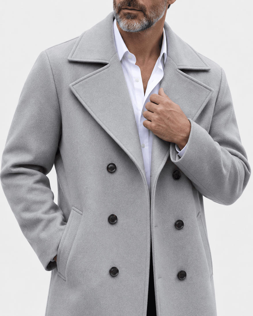 Close-up of the light gray coat's wide lapel and double row of buttons with a hand at the collar