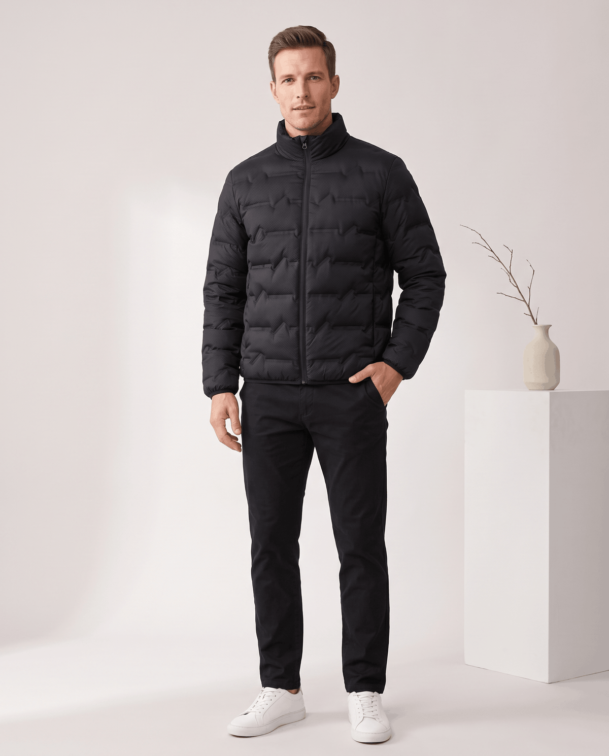 Black jacket styled with black trousers and white sneakers, full-length view