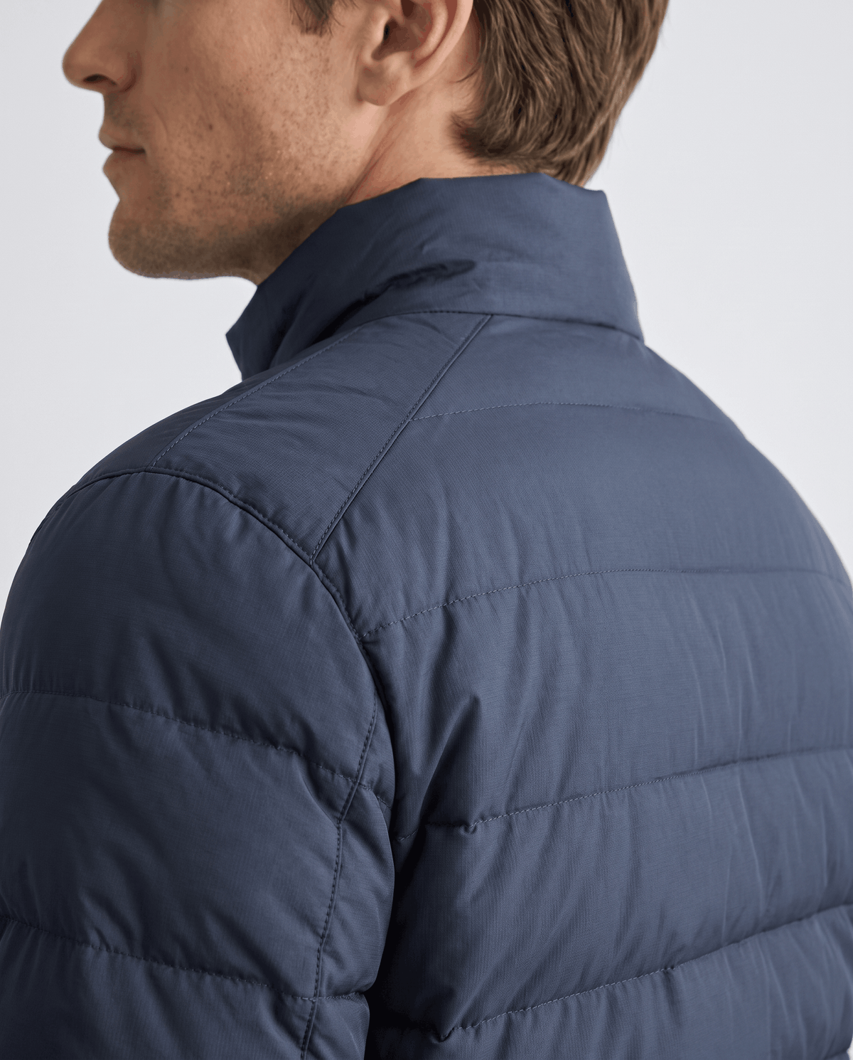 Navy shoulder and collar detail showing the yoke seam and upright collar height