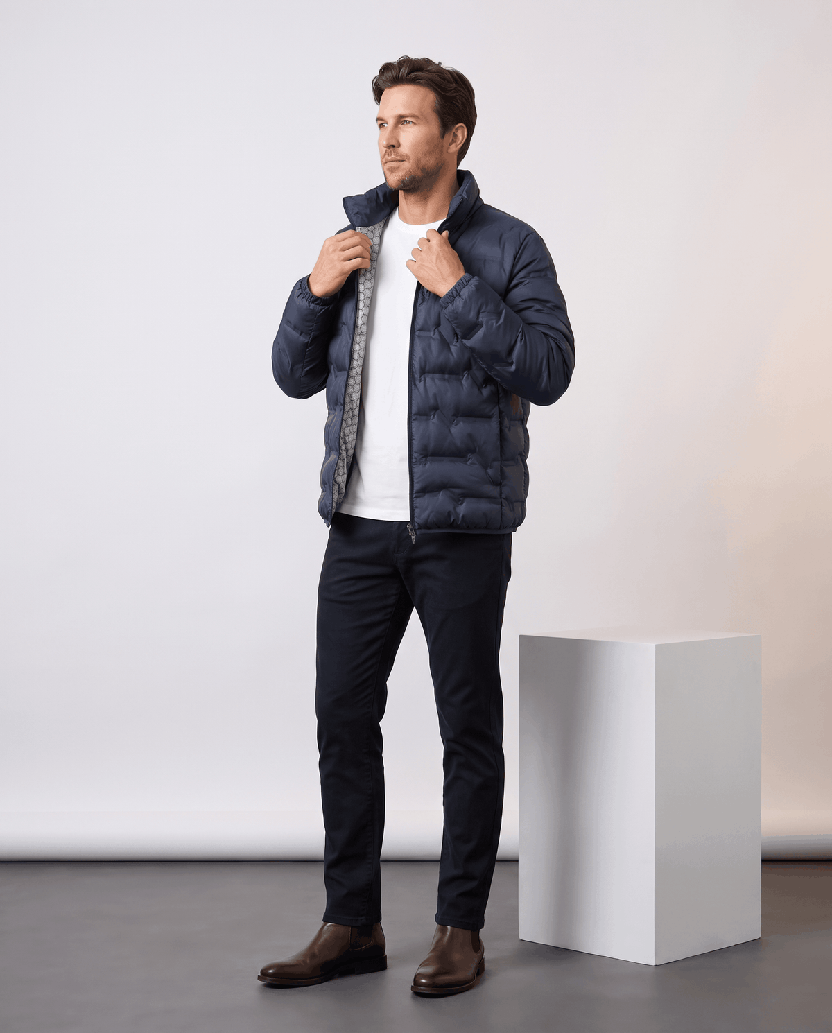 Navy jacket styled with dark trousers and brown boots, full-length standing view
