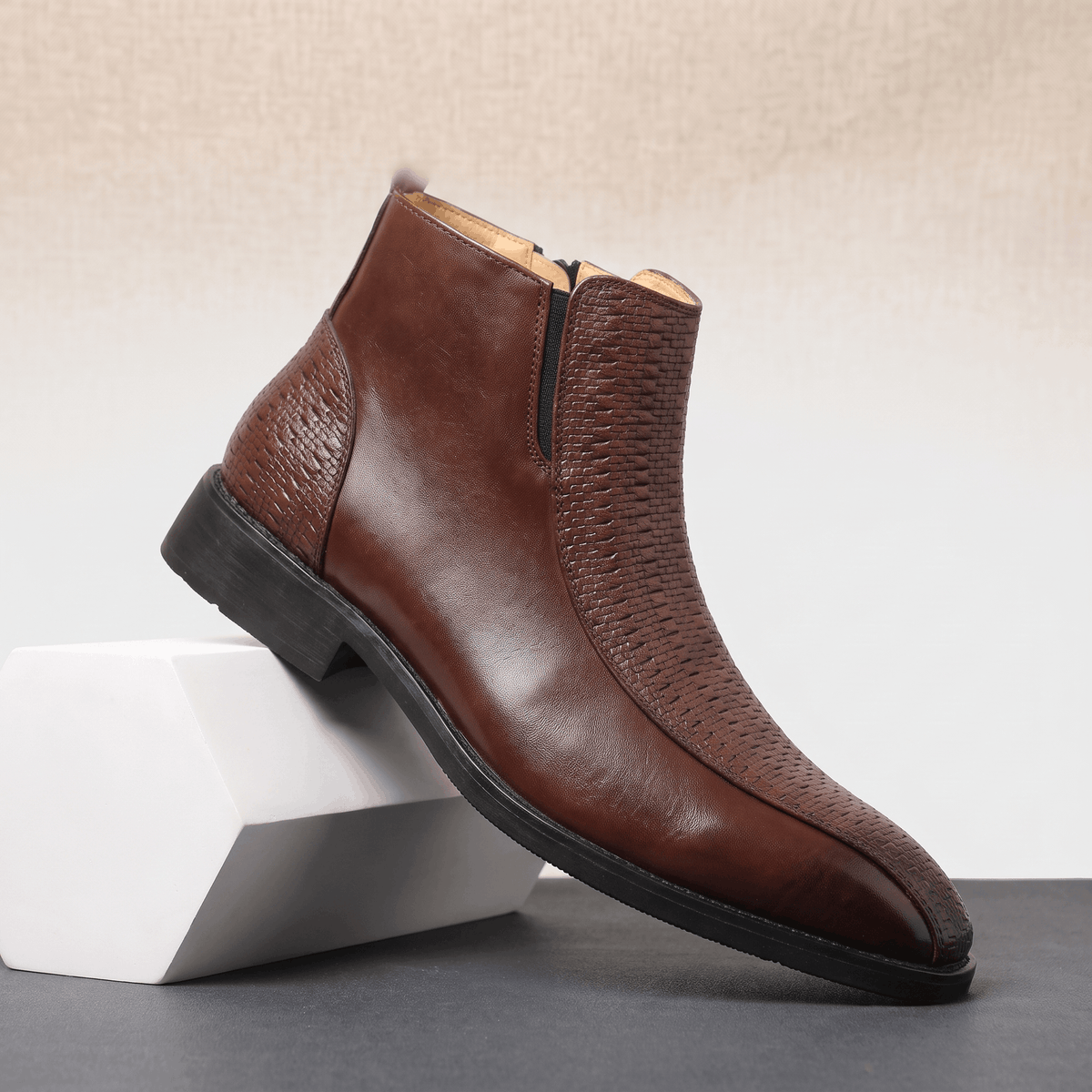 Brown leather ankle boot with basketweave embossed panels, side zip, and a low stacked heel with a squared toe.
