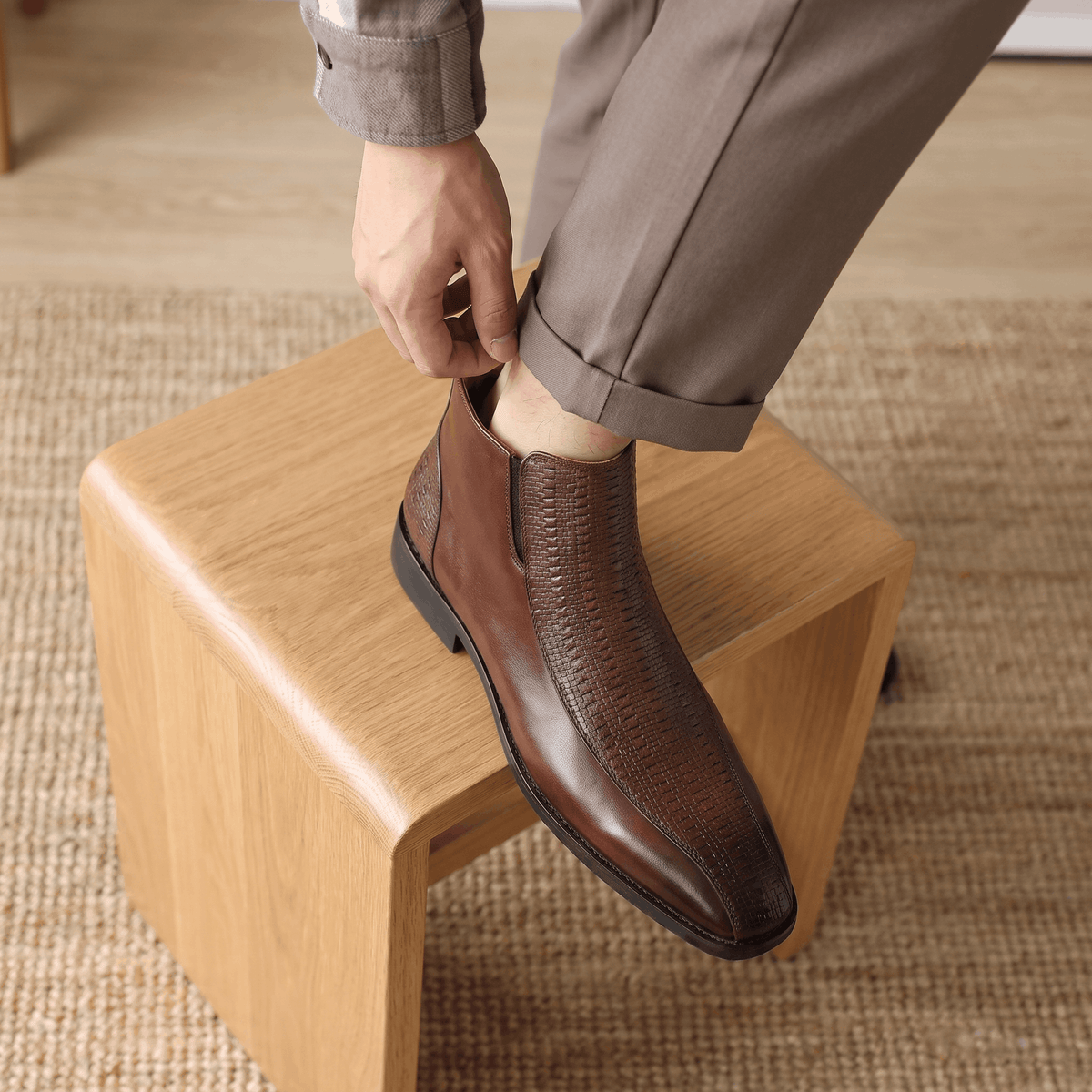 Brown leather ankle boots featuring a basketweave embossed quarter panel, side zip, and a softly squared toe.