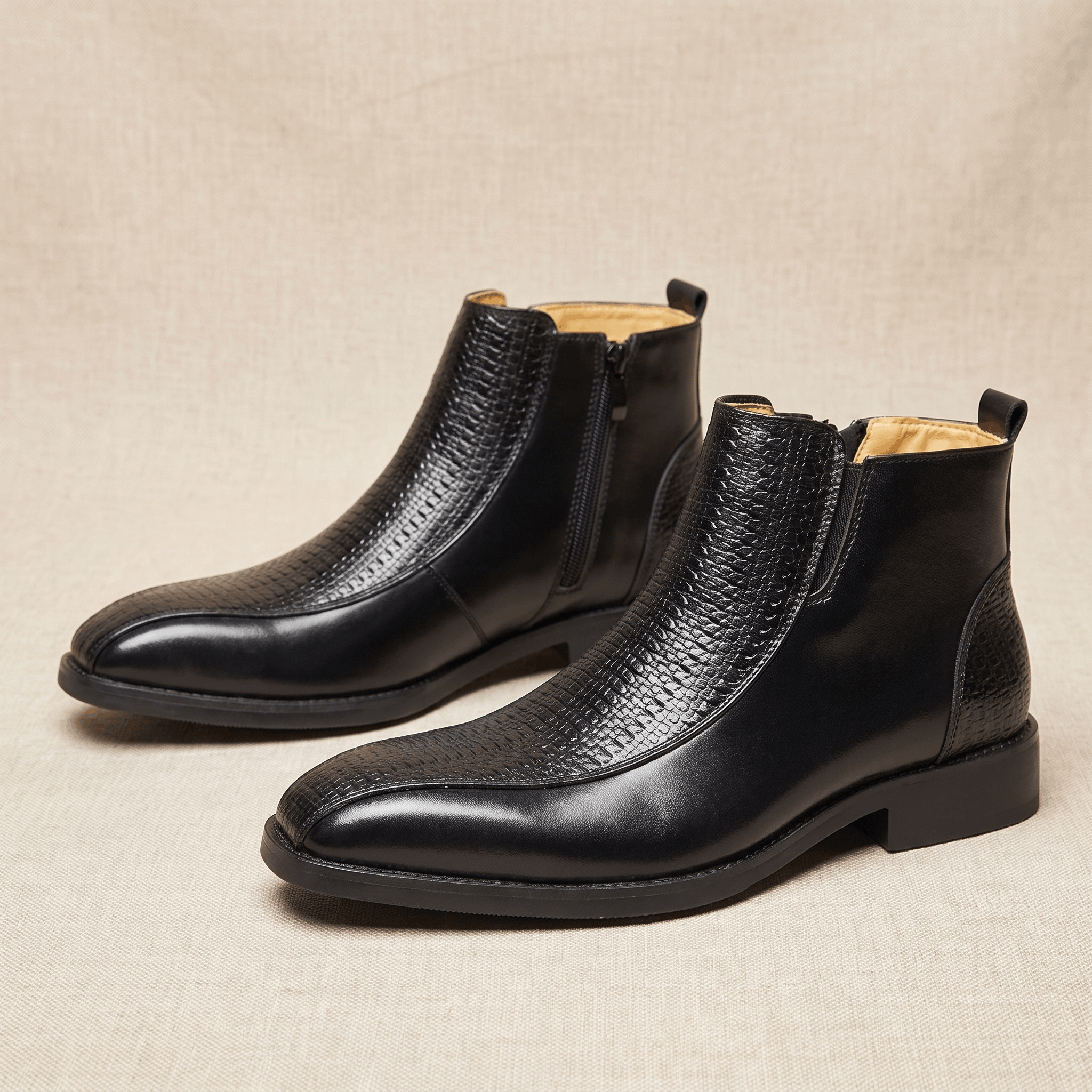 Black leather ankle boots featuring a basketweave embossed quarter panel, side zip closure, and a softly squared toe.