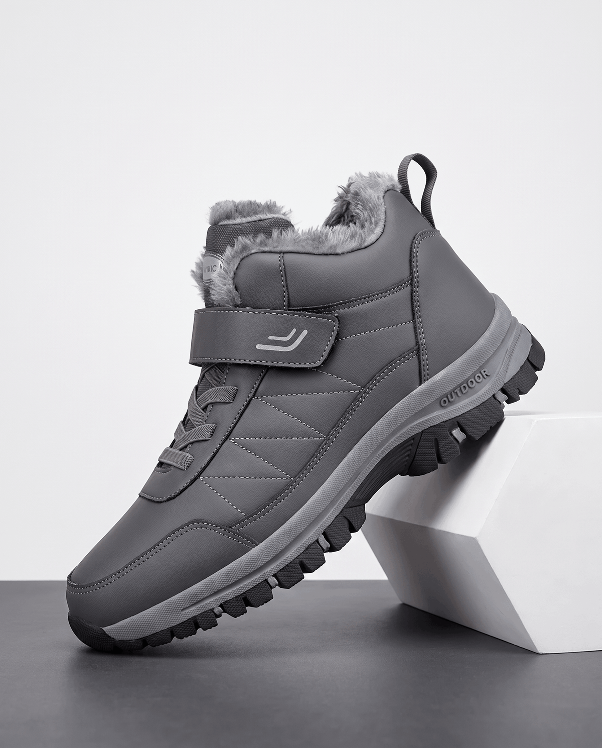 Gray insulated winter boot shown on a white pedestal.
