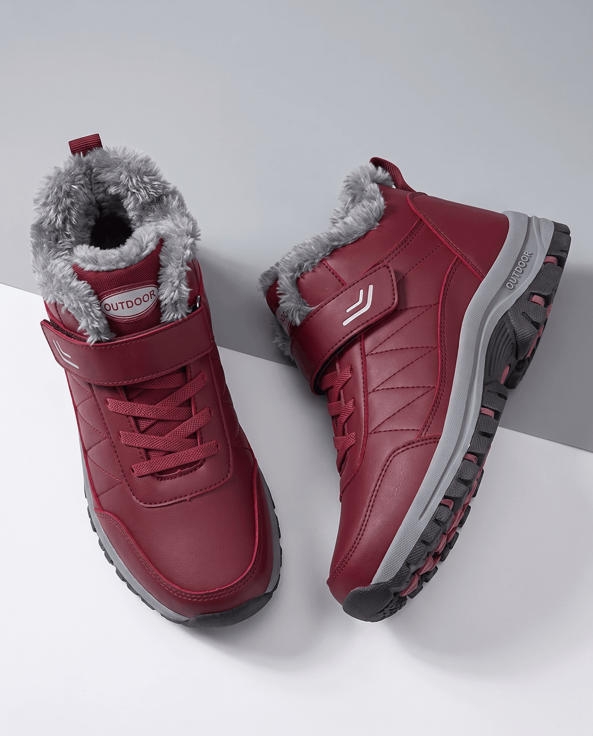 Pair of red insulated lace-up winter boots with fleece lining displayed from above.