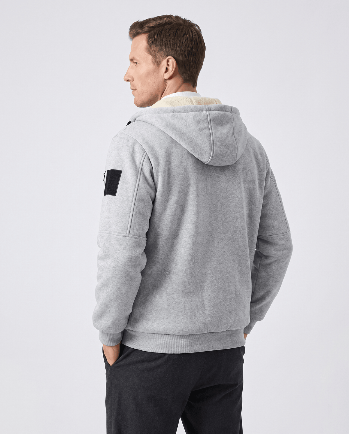 Back of gray hooded jacket showing the hood, sleeve patch pocket and ribbed cuffs