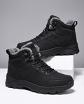 Black winter ankle boots with lace-up fronts, padded collars, and rugged lug soles displayed on white blocks.