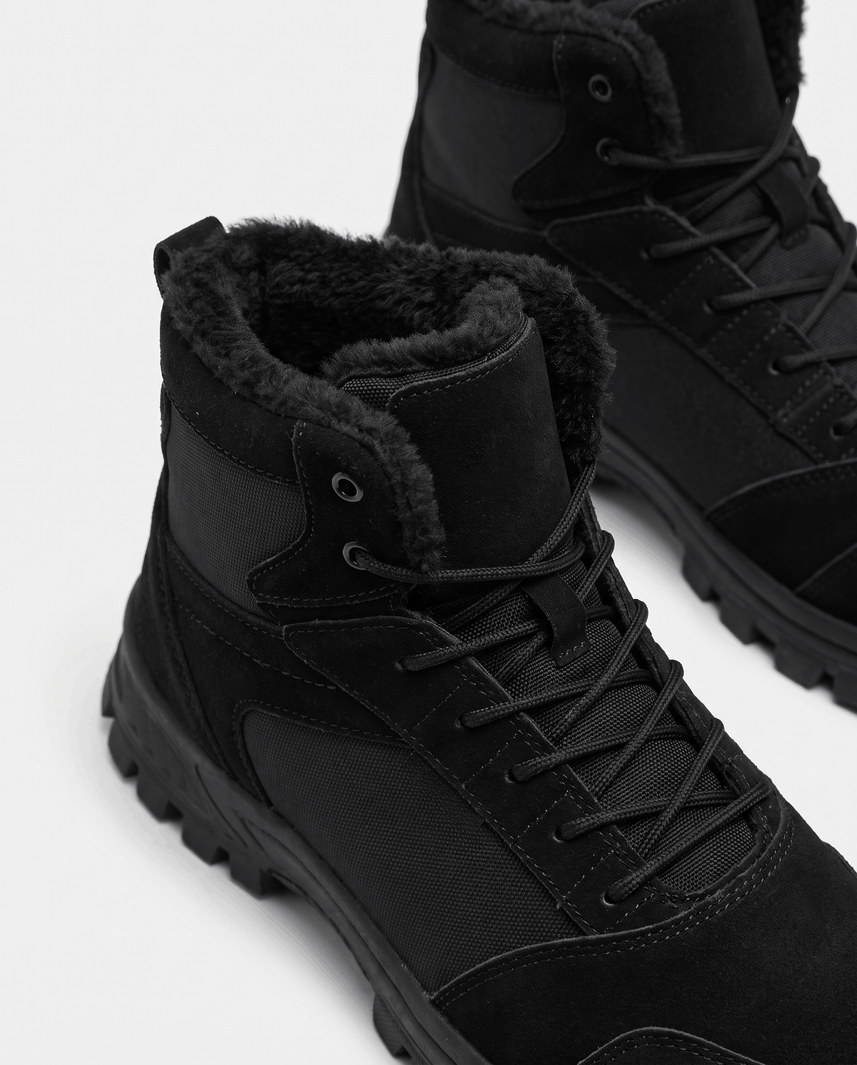 Black pair standing square on white, reinforced toe cap and woven side panels