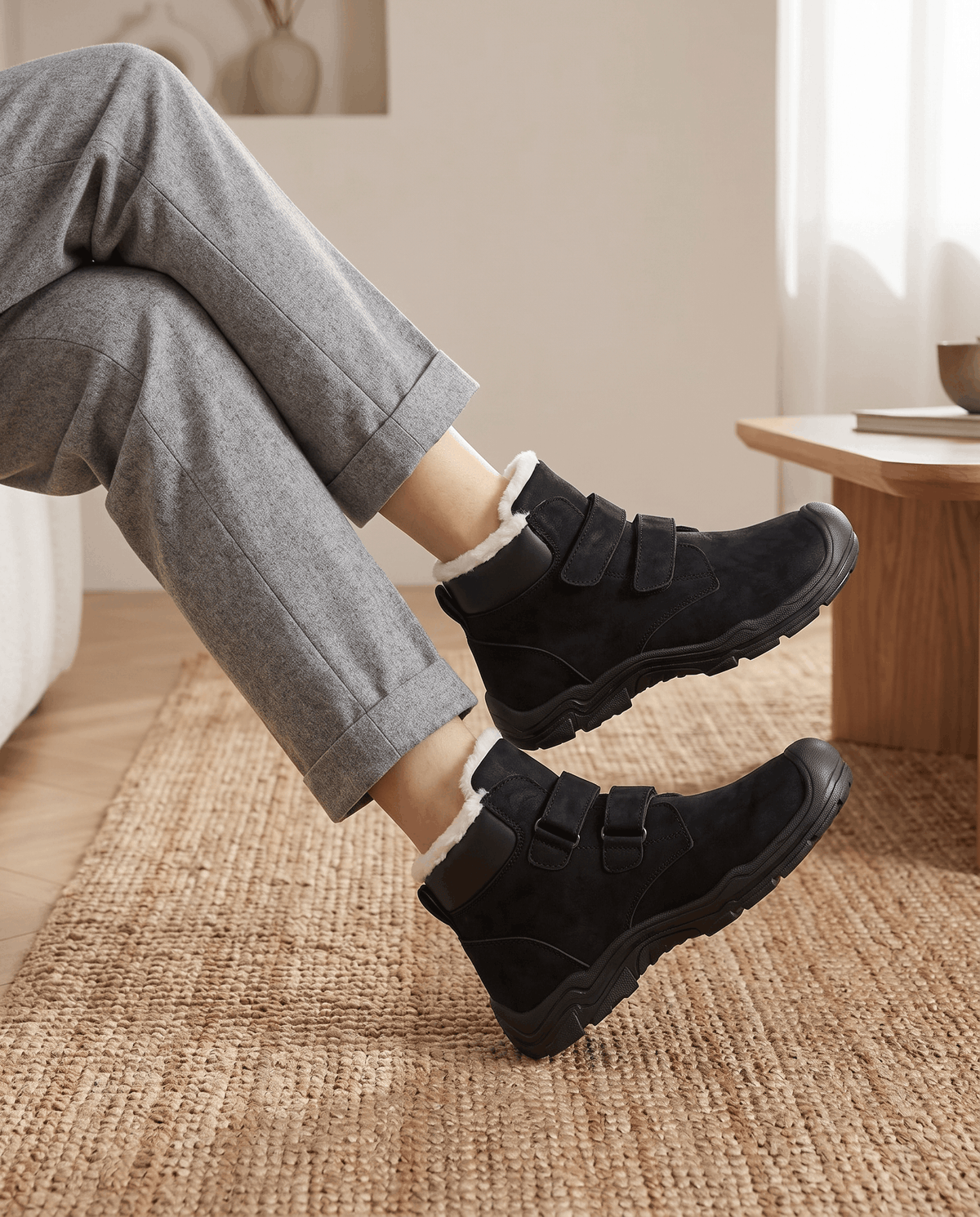Close-up of black insulated boots worn with gray pants.