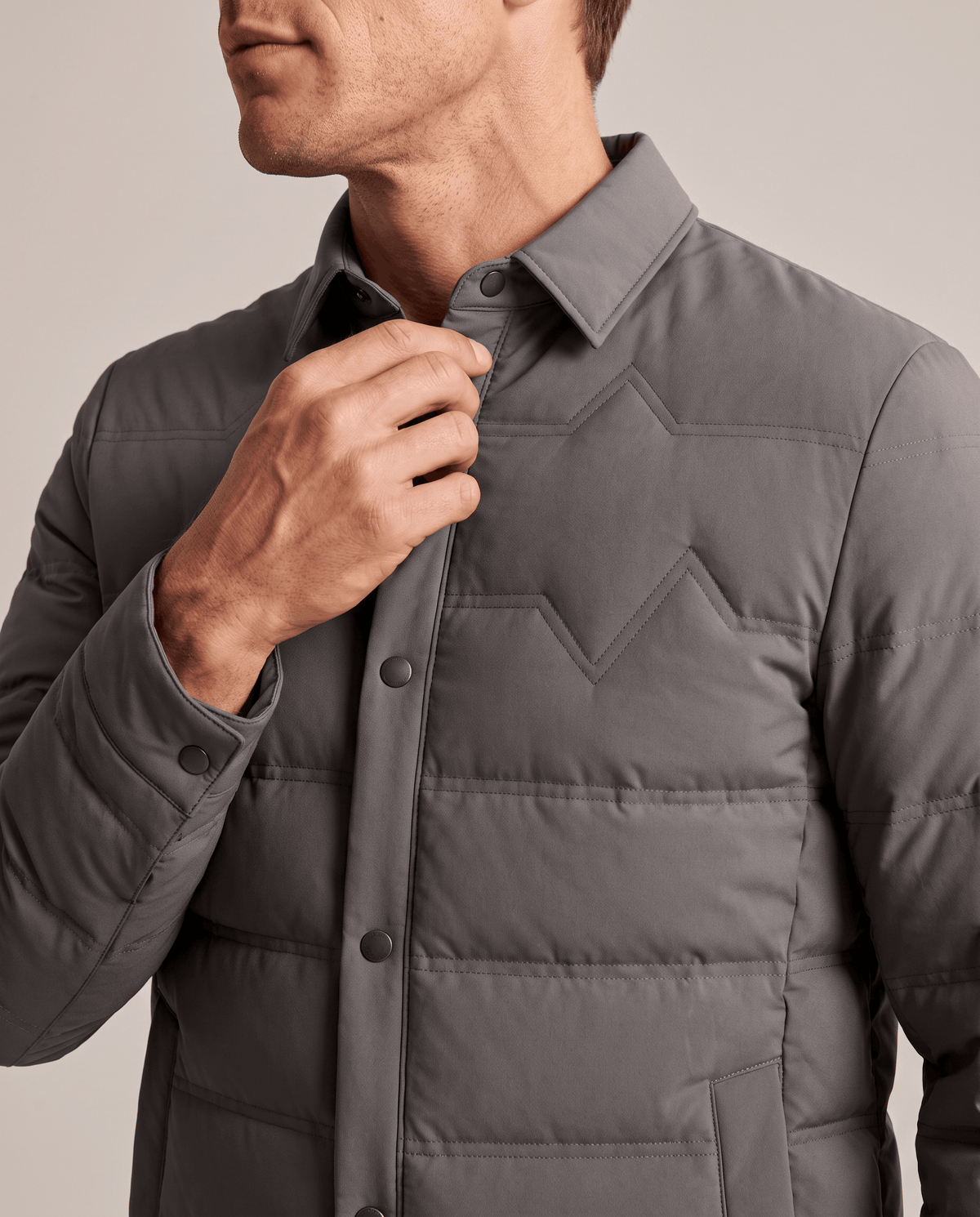 Close-up of the point collar and snap placket on a gray puffer jacket
