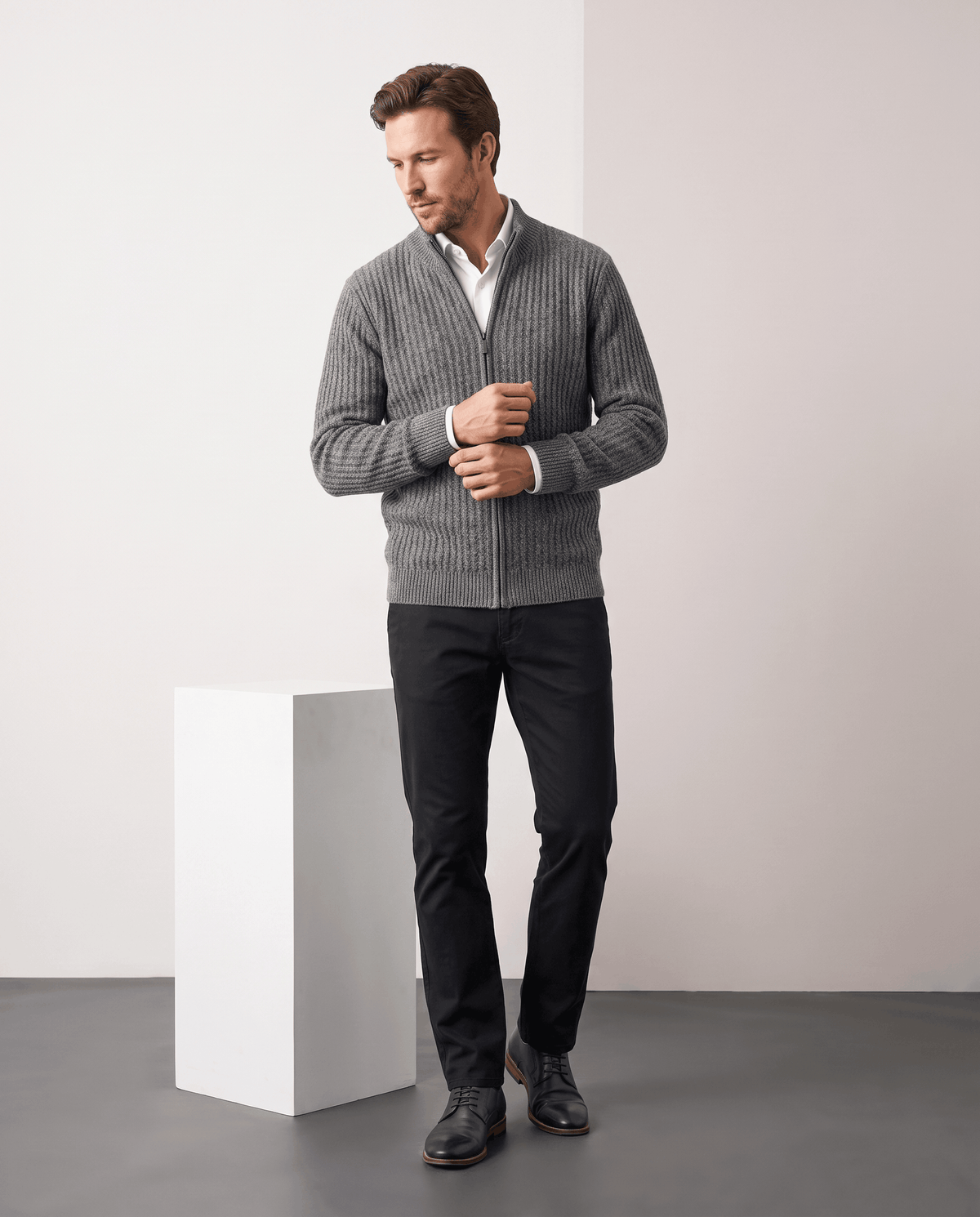 Full-length view of a man wearing the Julian gray cardigan with black trousers