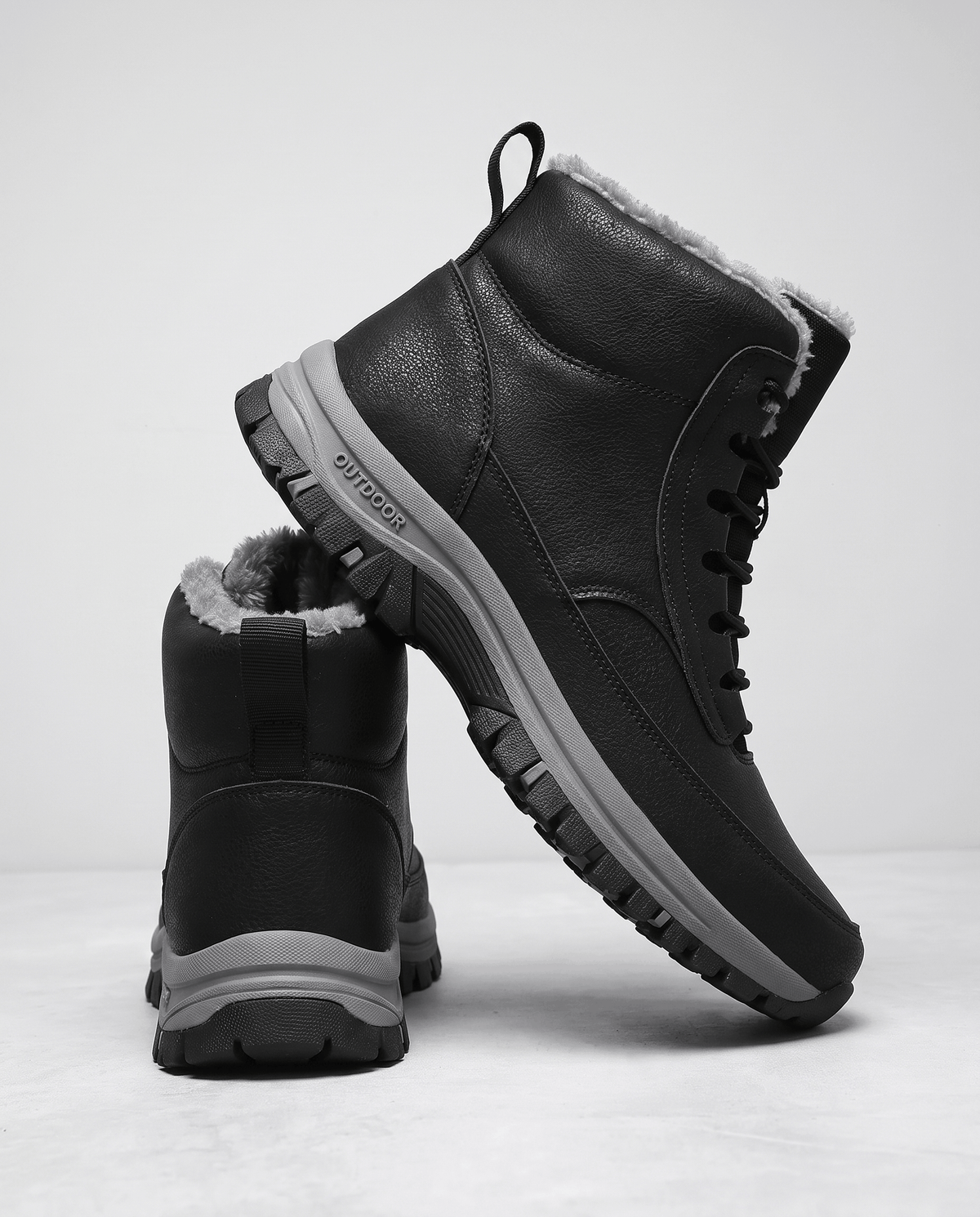 Black boot on a plain white background with the full outsole in view