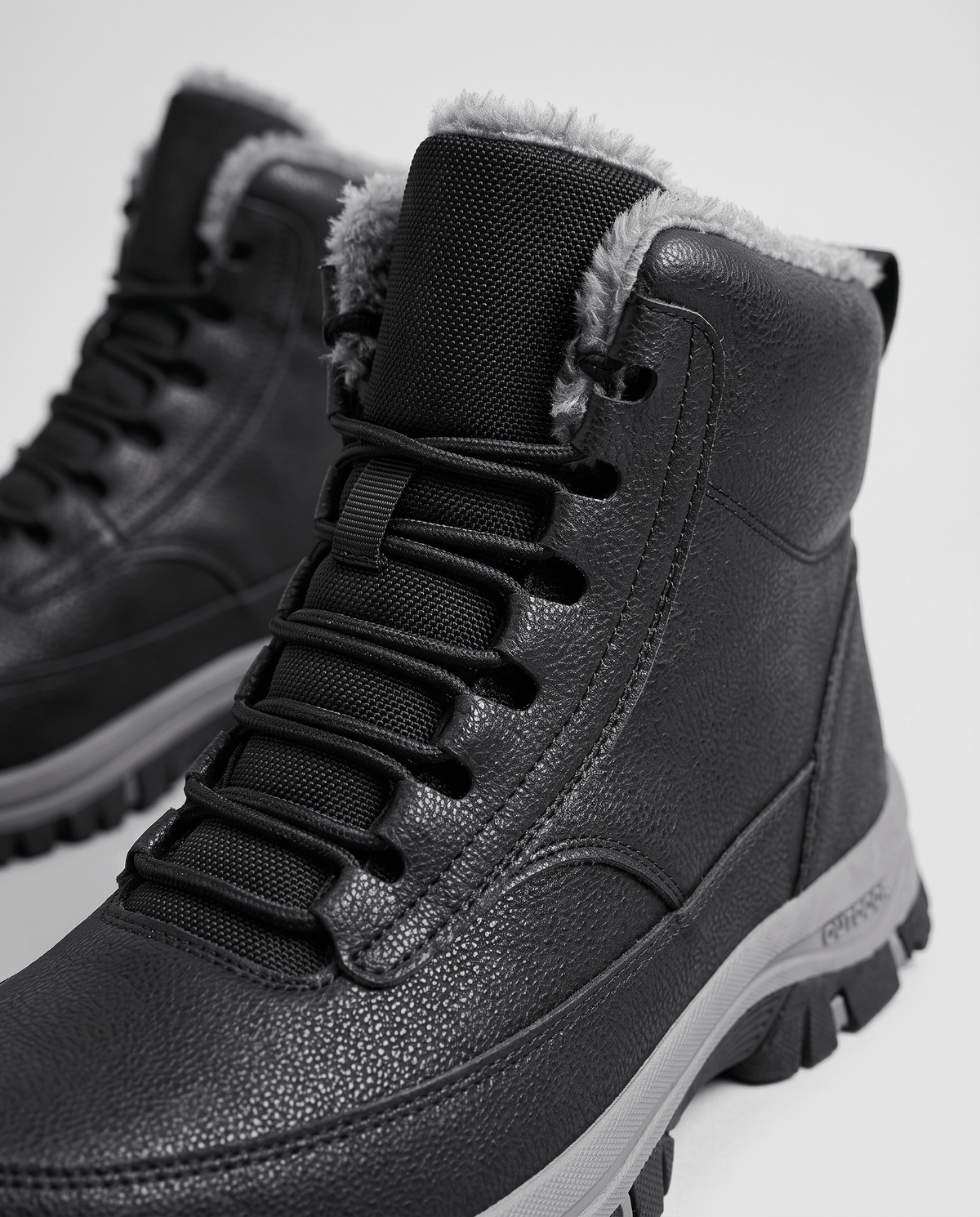 Black boot angled to show the padded tongue and grippy rubber outsole