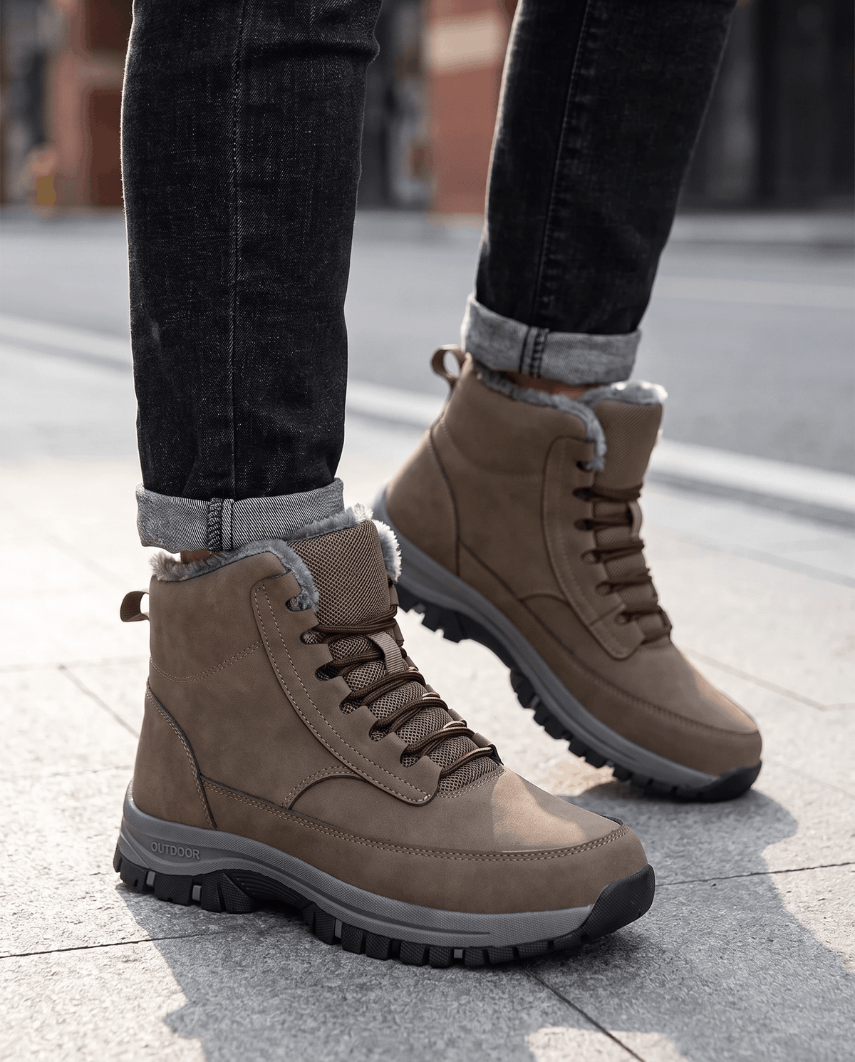 Cropped view of black boots worn under tapered dark trousers outdoors