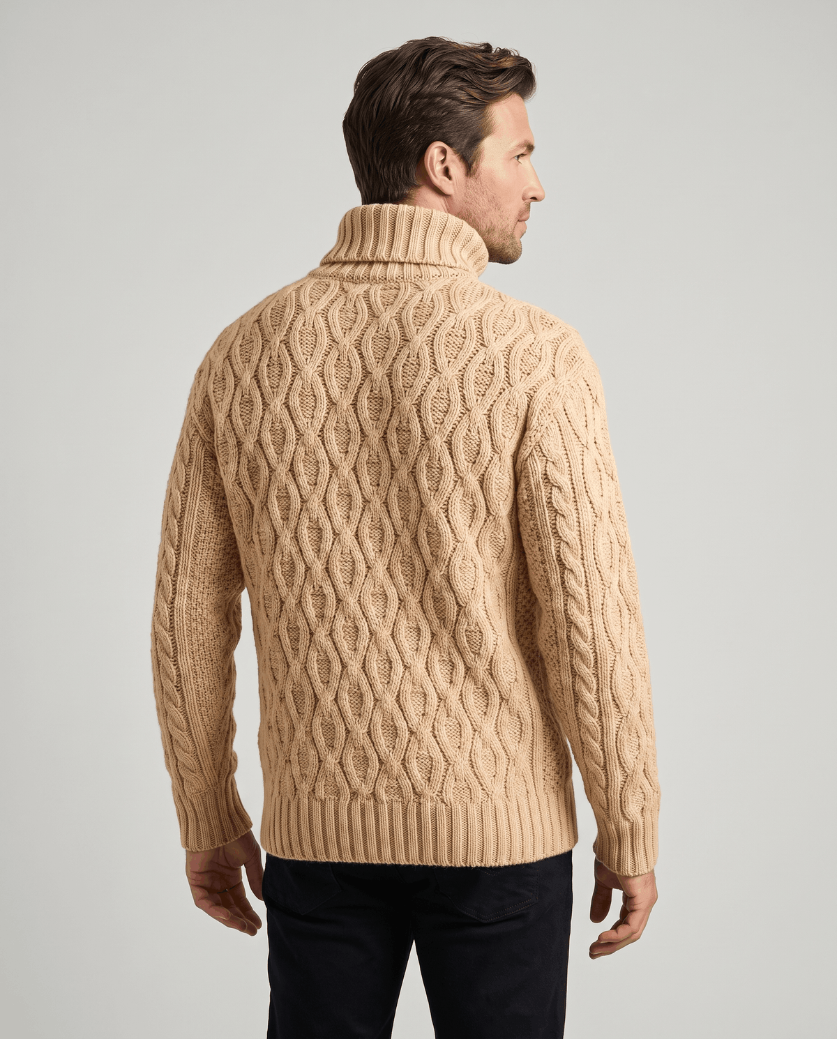 Back view of sand beige turtleneck with honeycomb cables and ribbed hem