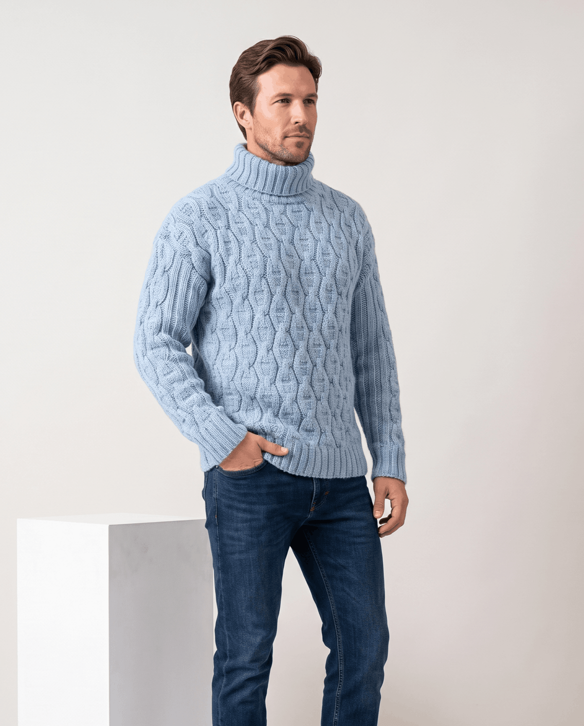 Model in light blue cable turtleneck with jeans, hand in pocket