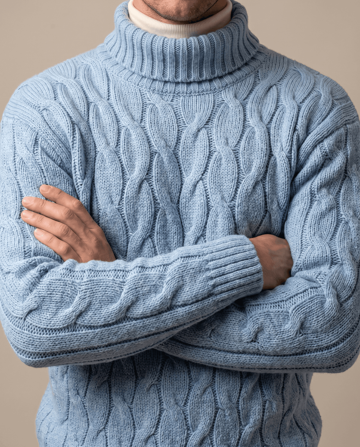Light blue honeycomb knit over cream underlayer with arm folded across chest