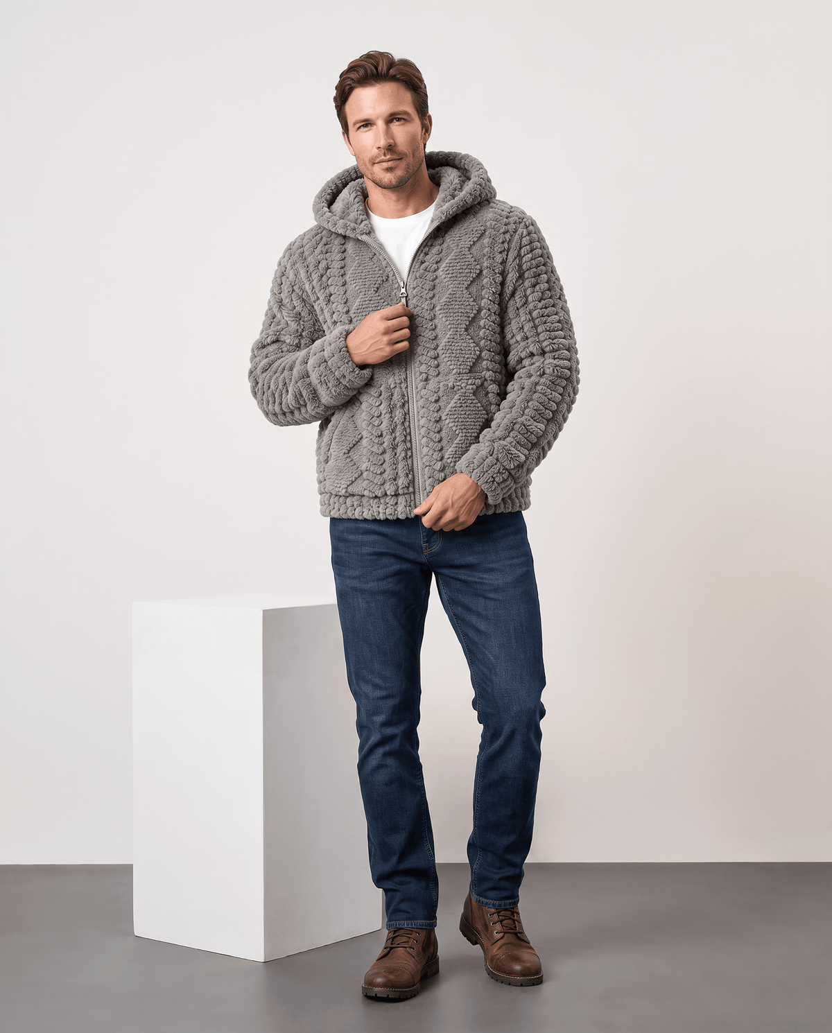 Full-length view of gray hooded jacket styled with dark jeans and brown shoes