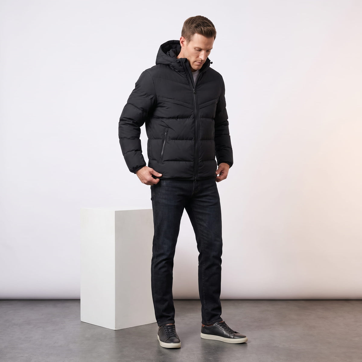 Black jacket styled full-length with dark jeans and grey sneakers