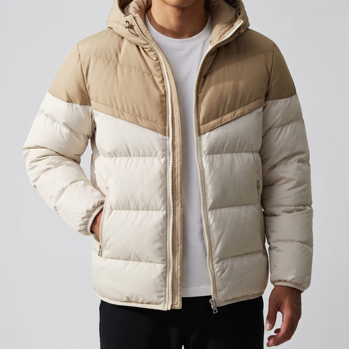 Cream and tan jacket zipped, hood up against the collar, hands in pockets